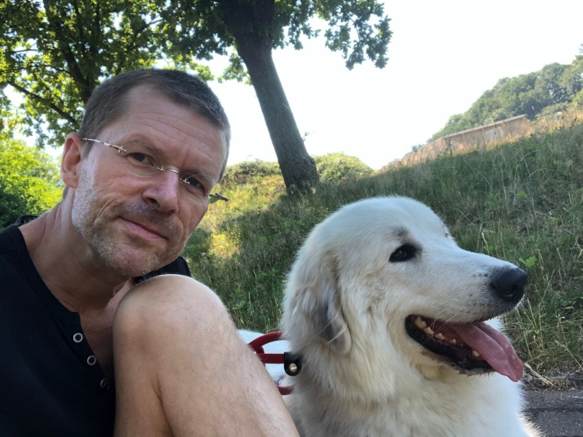 Die Bella beobachtet mit ihrem großen Mensch die Autos. Wanderpause im Schatten.