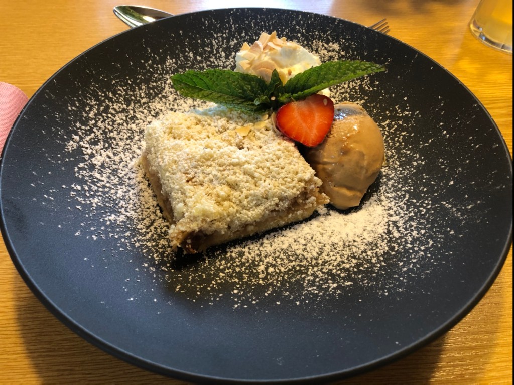 Gedeckter Apfel-Streuselkuchen mit Carameleis und Obers
