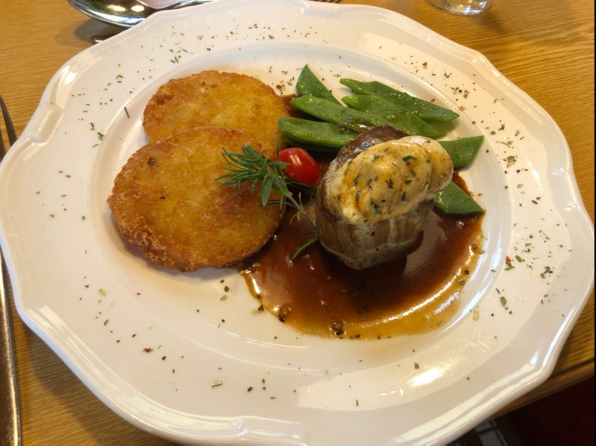 Rosa gebratenes Hüftsteak mit Kräuterbutter, Erdäpfelrösti und breiten Bohnen